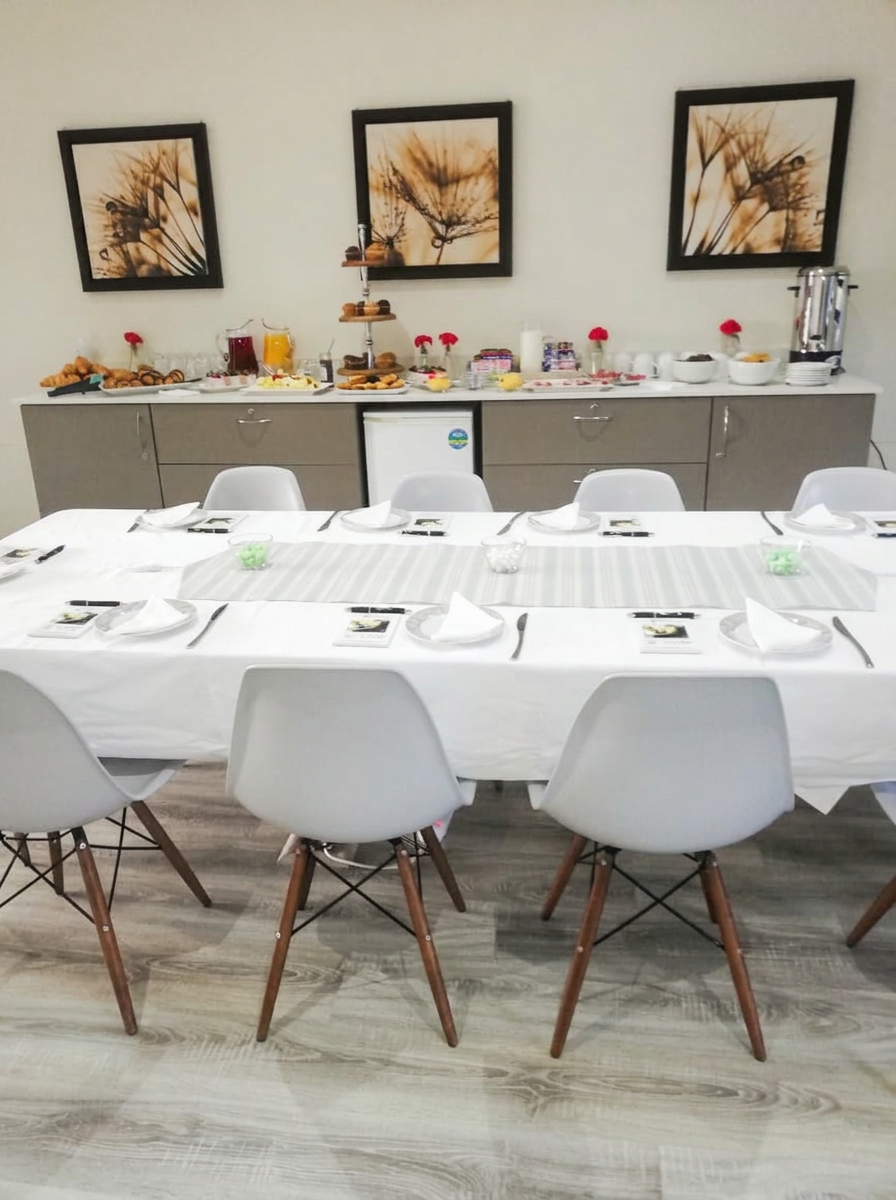 Boardroom table seated for ten with the tea and pastry buffet counter set up along the back wall