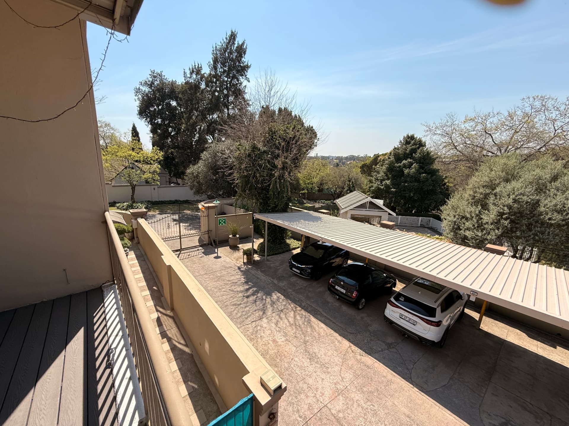 Elevated view from a Dunton balcony over the entrance gate, carports and trees