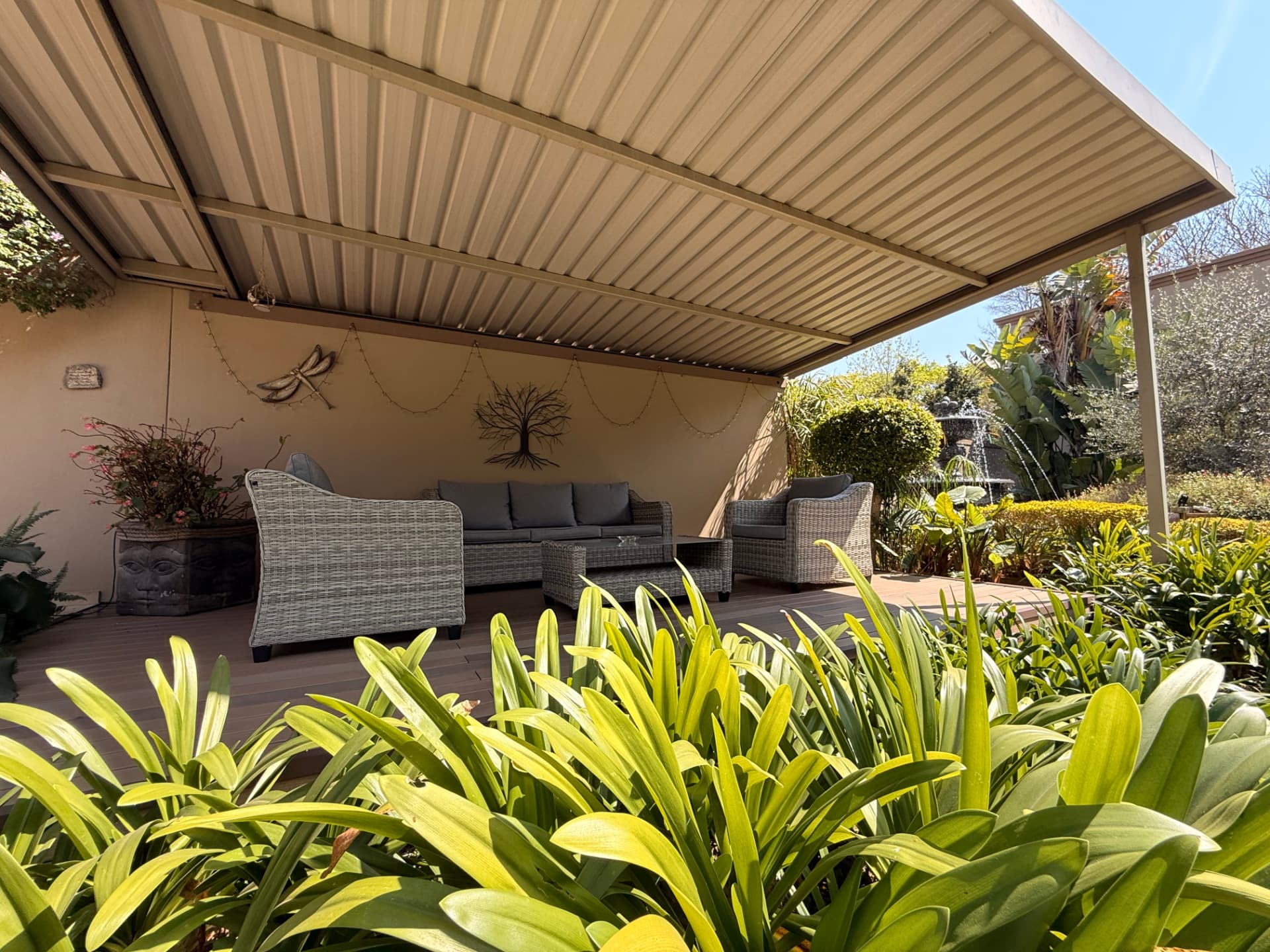 Covered garden lounge deck at Dunton with wicker seating and surrounding plants