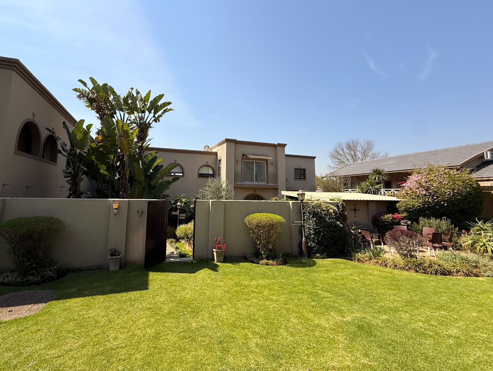 Lawn-side view of the Dunton building, garden and open gate