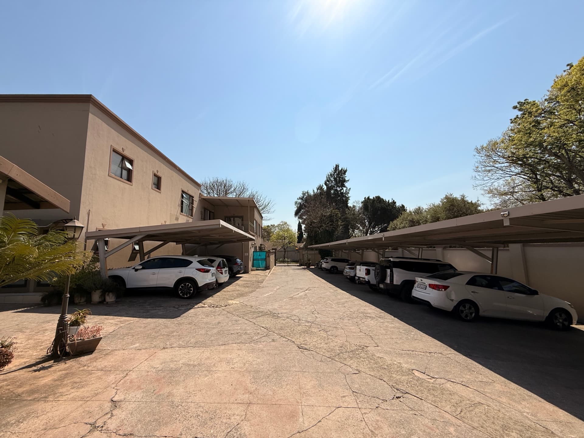 Covered carports on both sides of the Dunton parking courtyard with guest cars parked