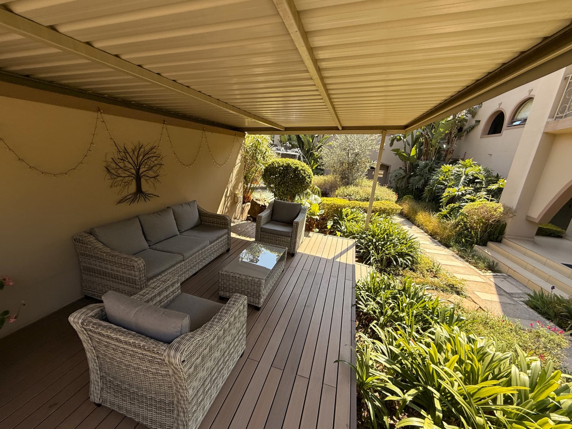 Covered garden lounge at Dunton with seating, timber deck and garden views