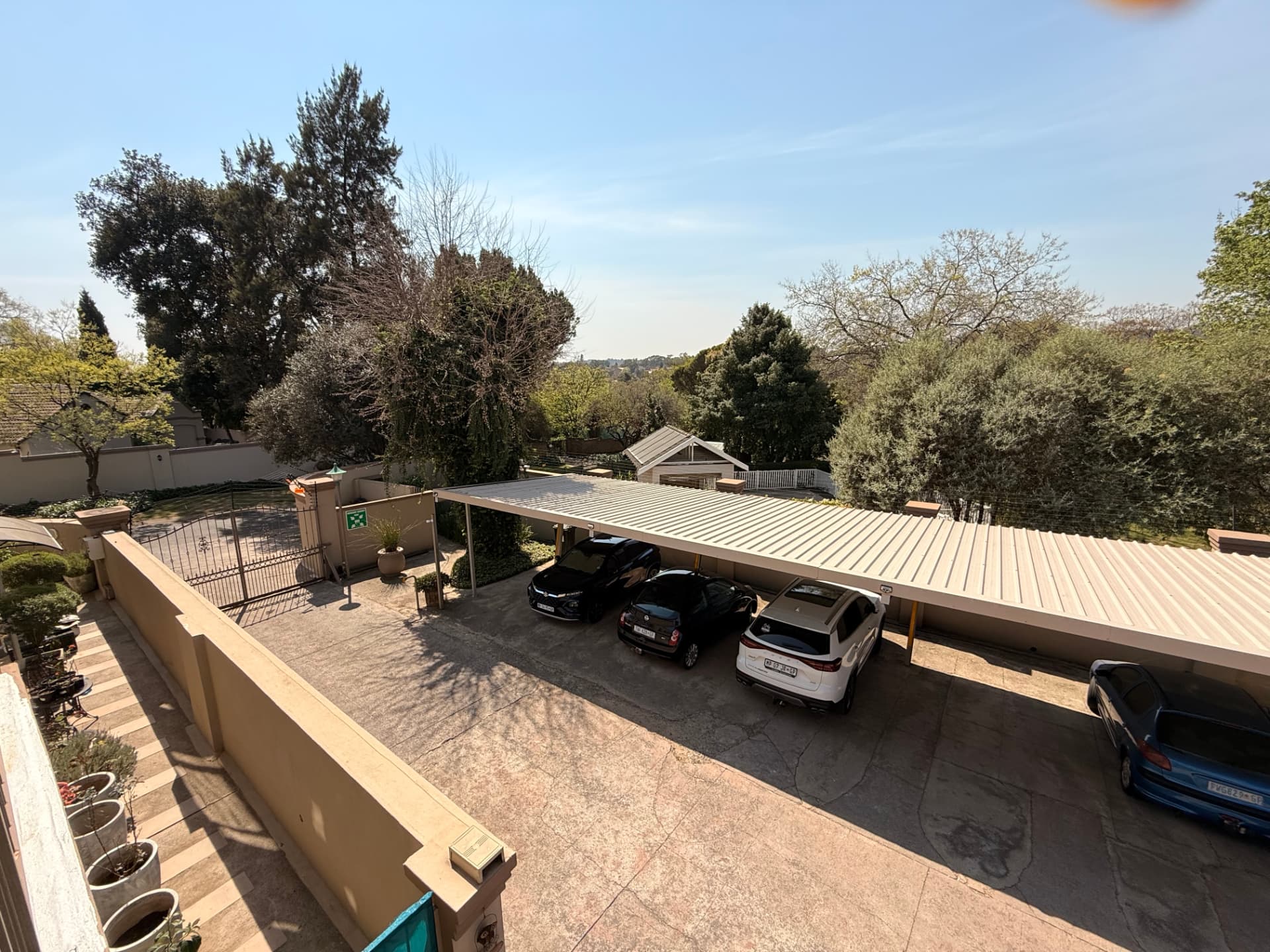 Elevated view over the Dunton car park, trees and the surrounding Rivonia suburb
