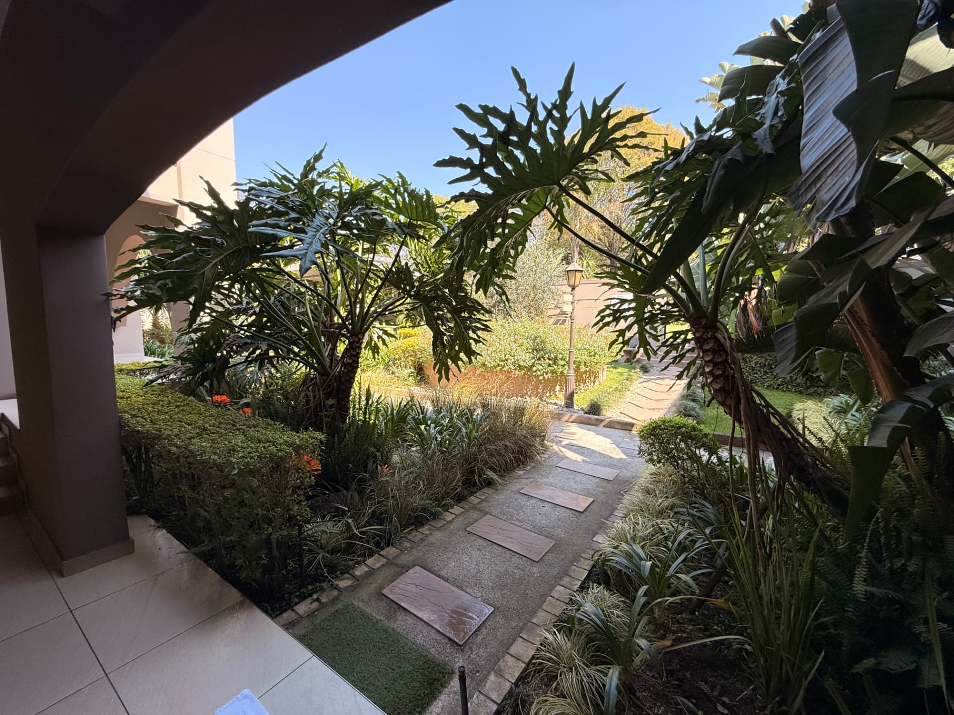 Lush garden path at Dunton viewed from beneath a covered patio