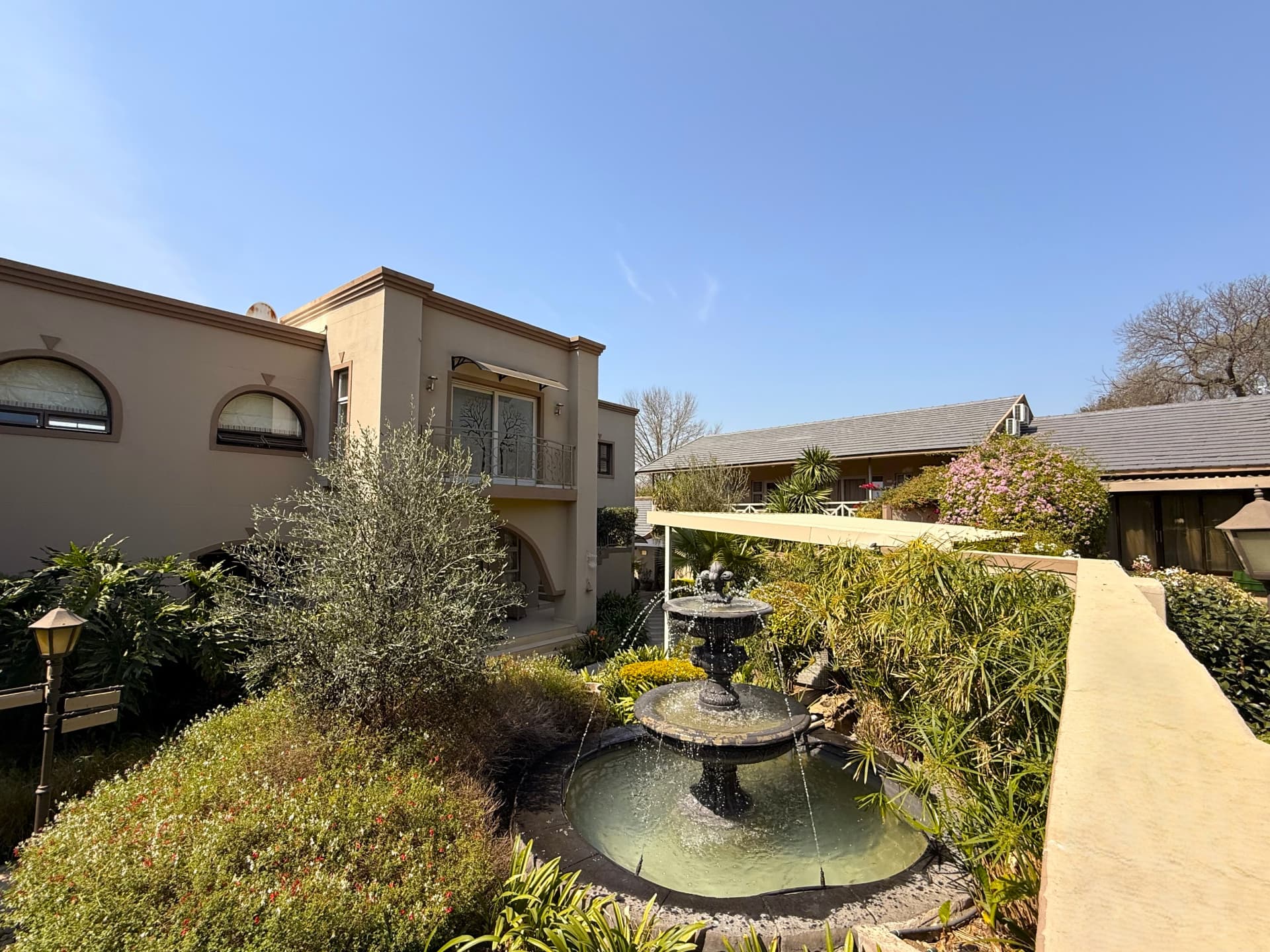 Wide view of the Dunton courtyard showing the building, fountain and planted beds