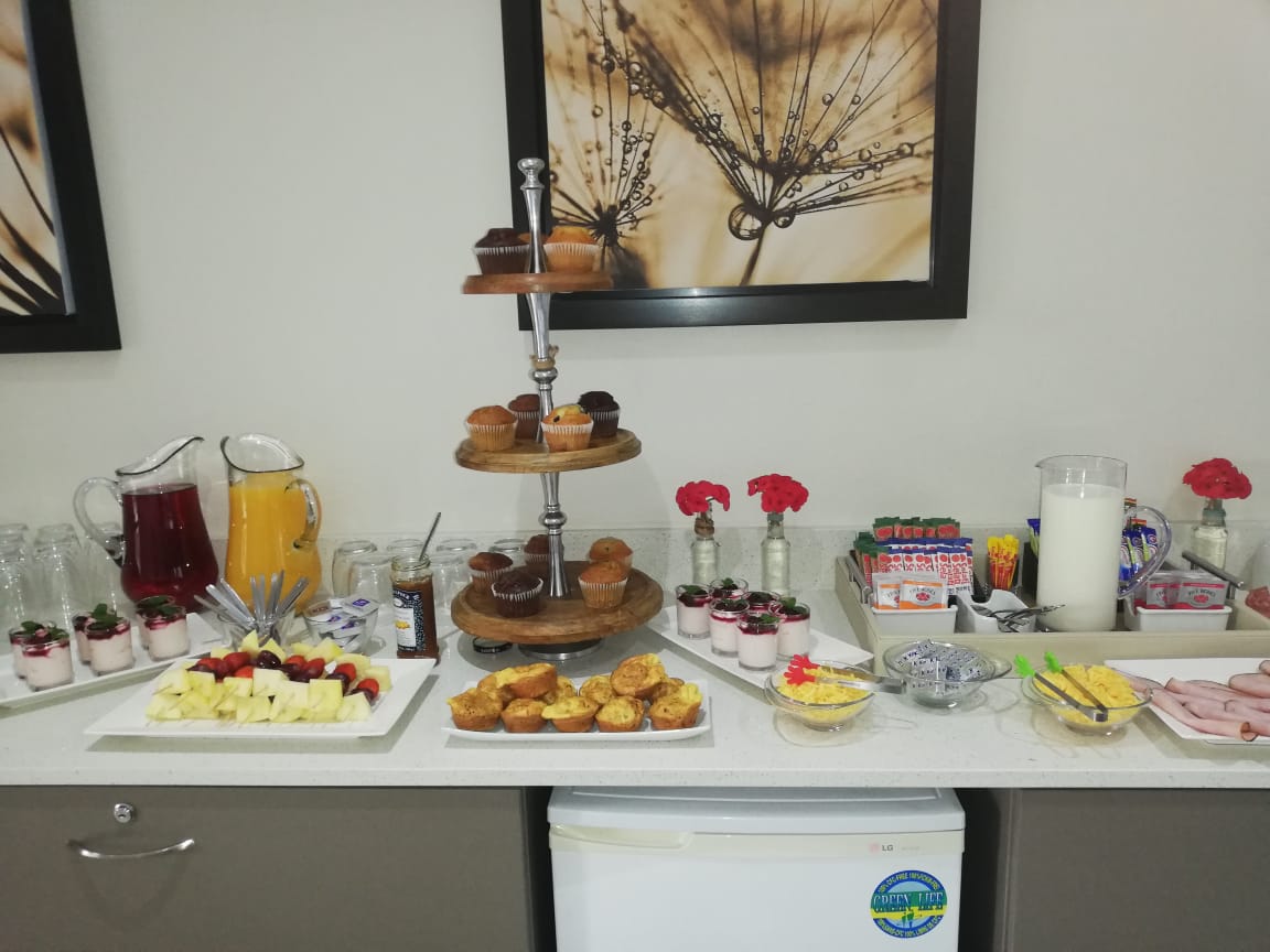 Conference breakfast spread with fresh fruit, muffins, yoghurt cups, juices and pastries