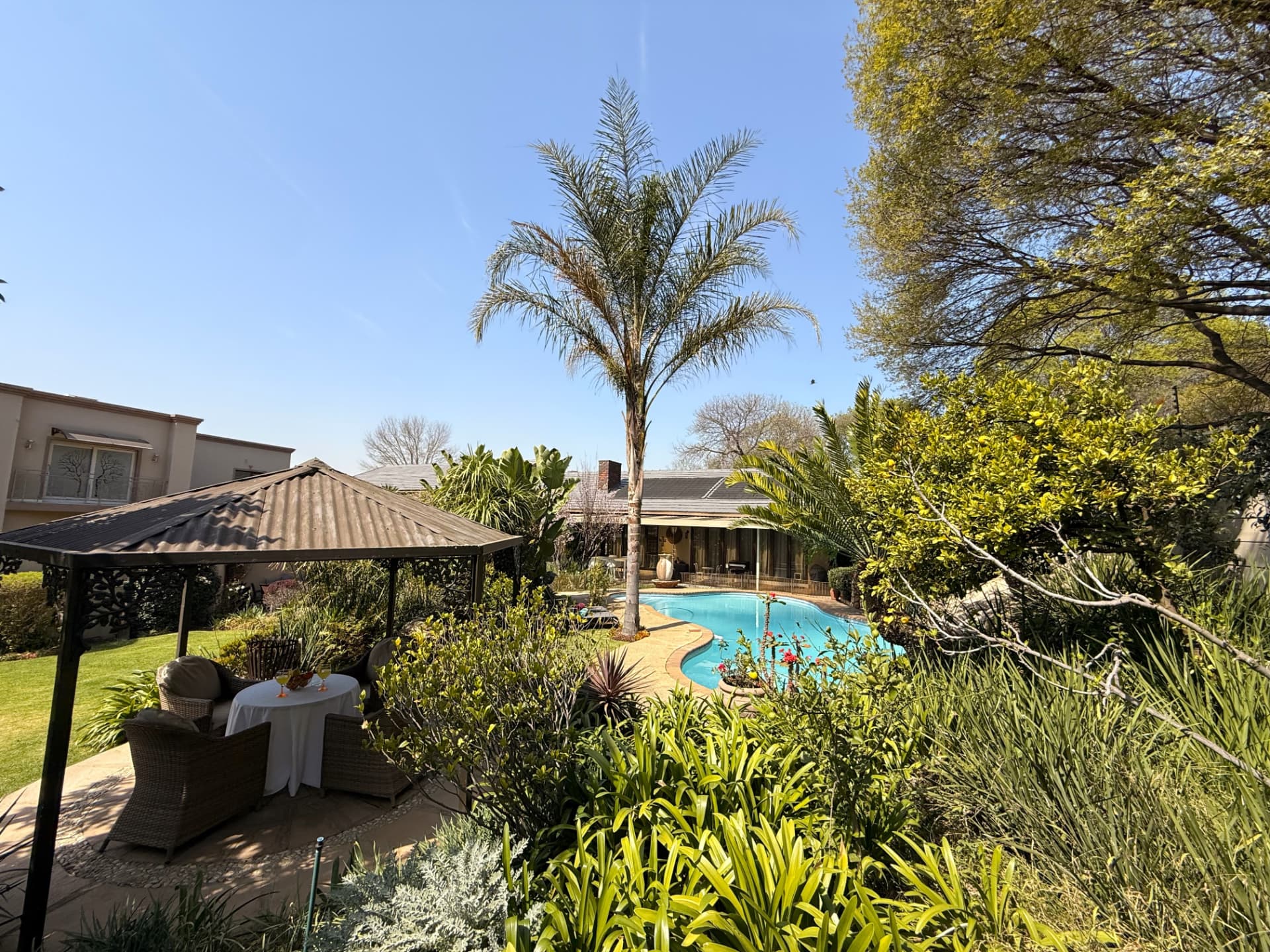 The lawn, gazebo and pool in the garden at Dunton Guest House